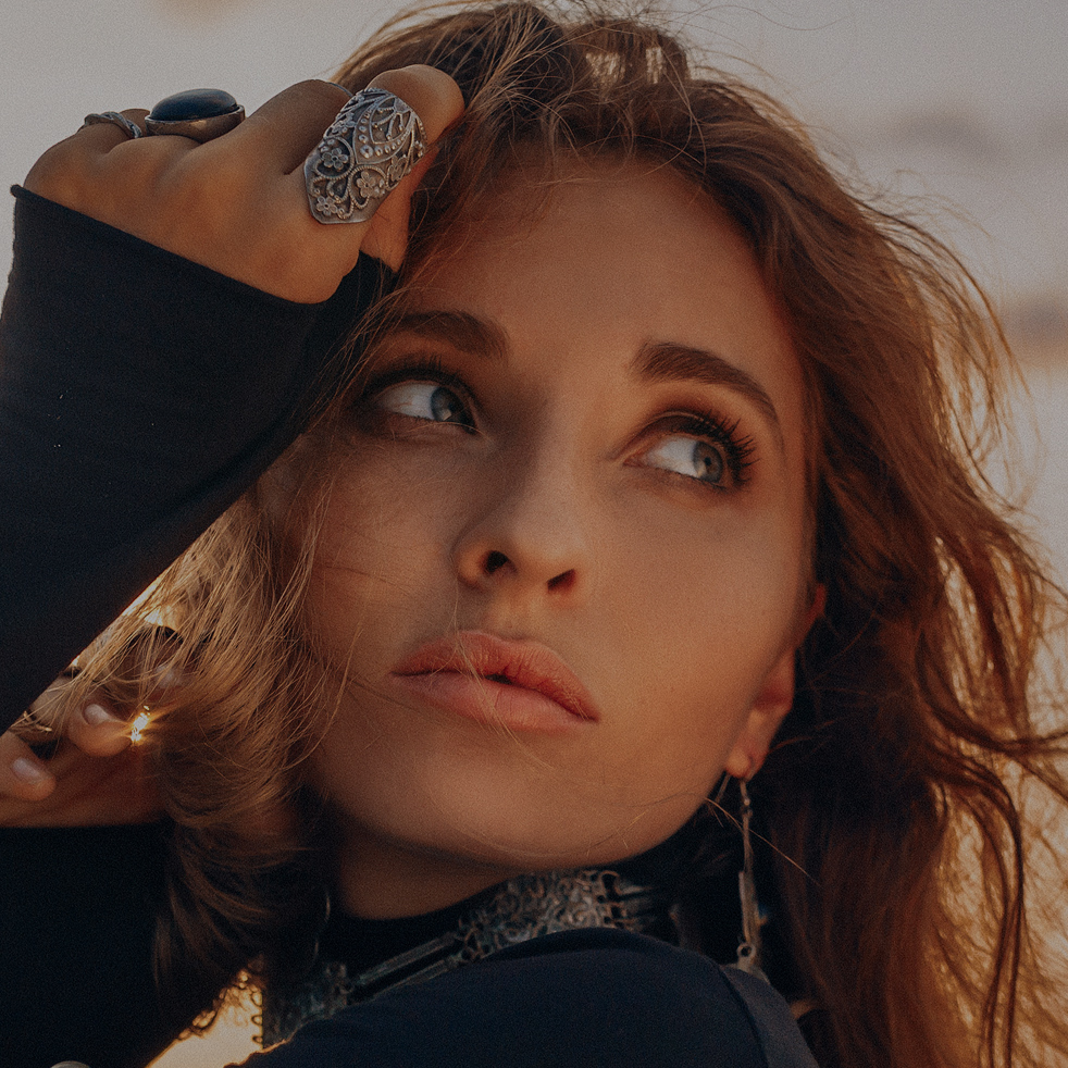 beautiful young tribal style woman on the beach at sunset