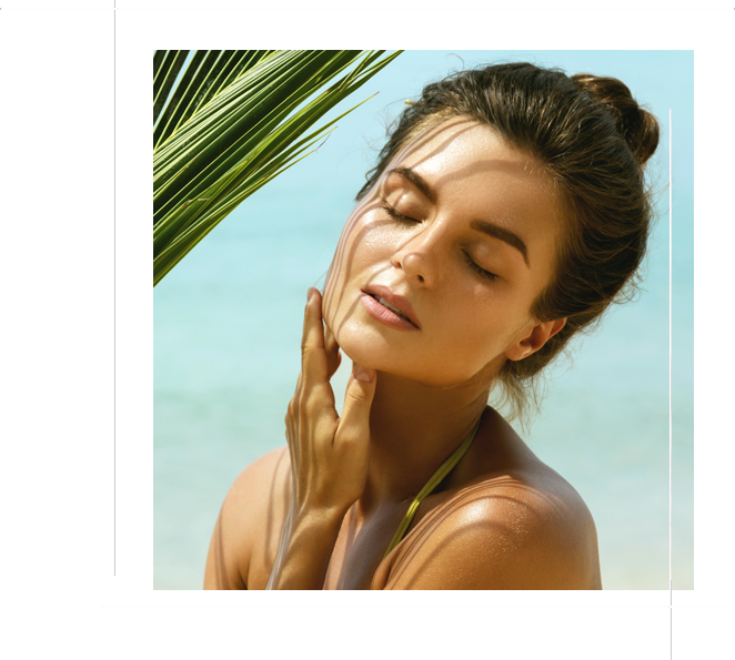 Beautiful woman with a palm leaf on the beach