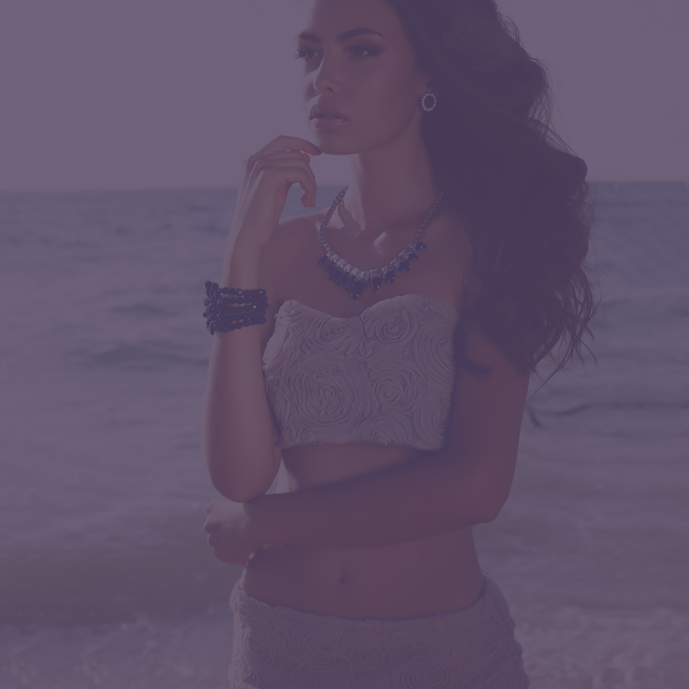beautiful girl with dark hair with accessories posing on beach